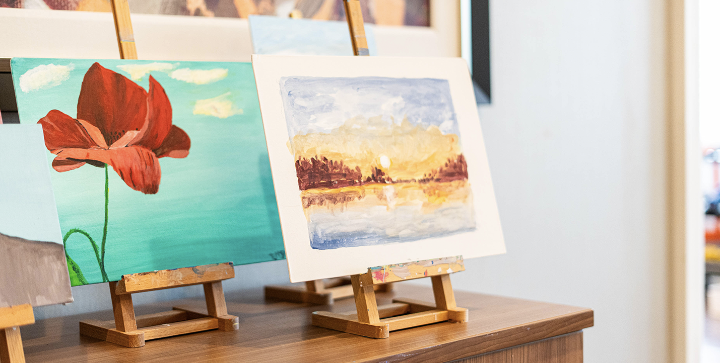 A photograph of two paintings created by seniors at a Verve Senior Living residence