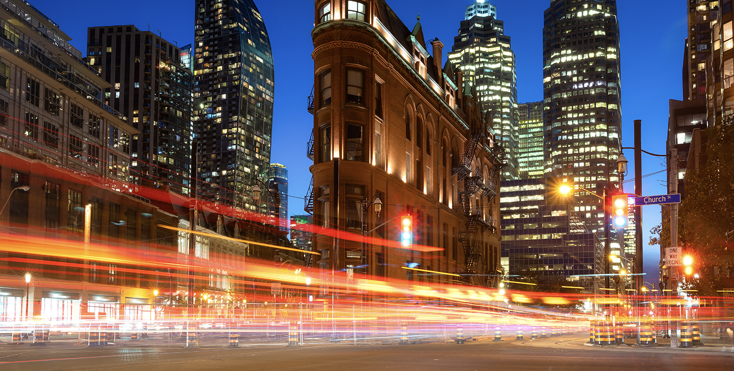 Motion blurring from vehicles passing at night in front of the historic Gooderham flatiron building in downtown Toronto
